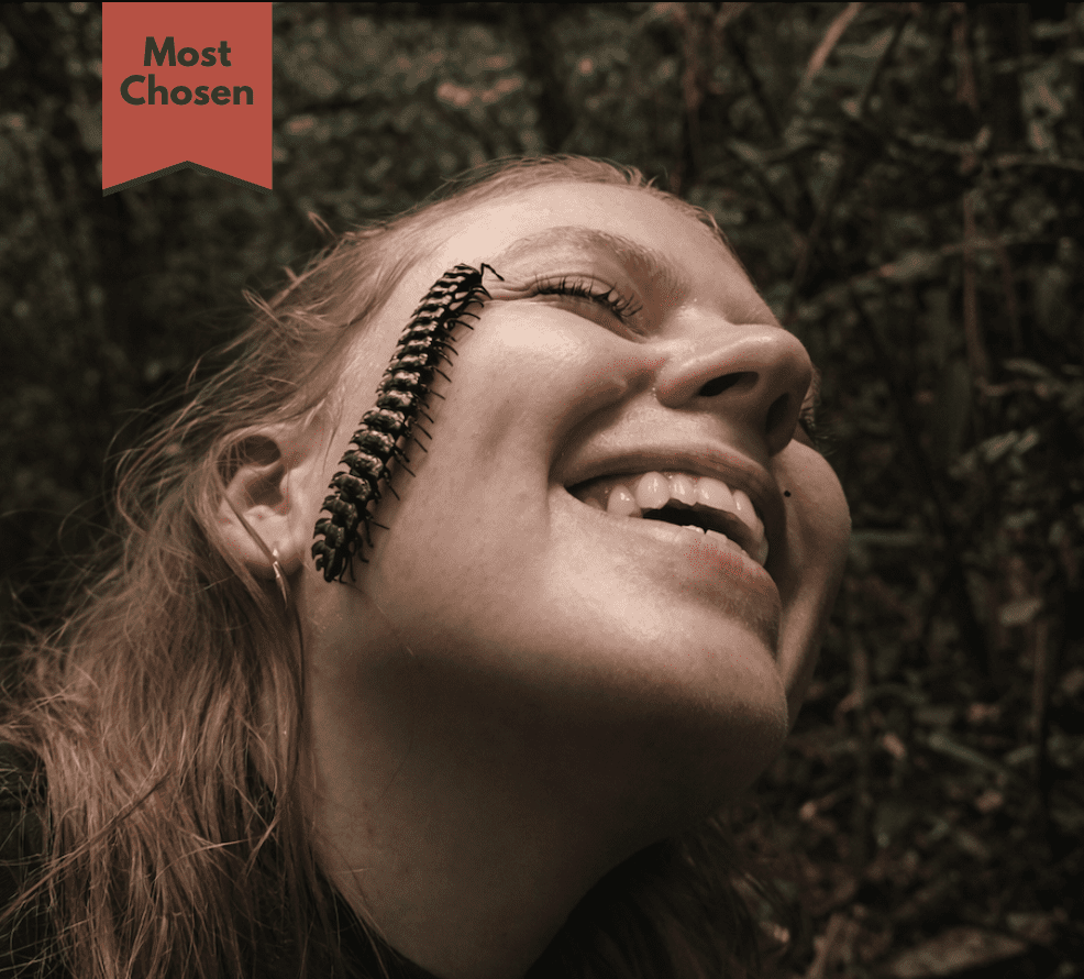 Traveler smiling with a large centipede on her face during a guided Amazon rainforest wildlife experience