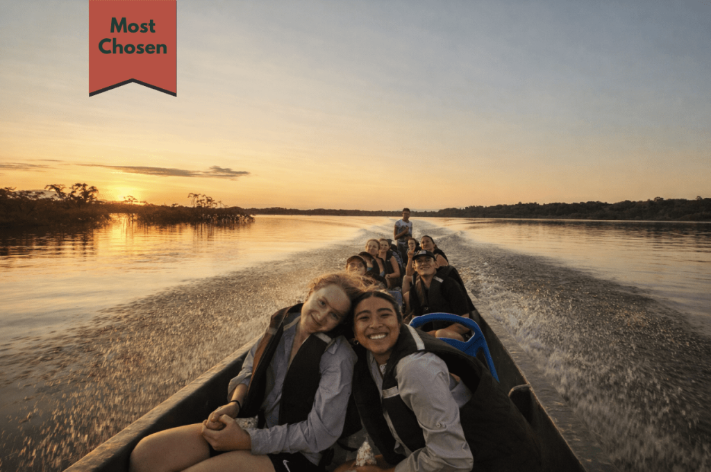 amazon-river-sunset-boat-tour-small-group Happy travelers on a small-group Amazon River boat tour at sunset, one of the most popular rainforest experiences