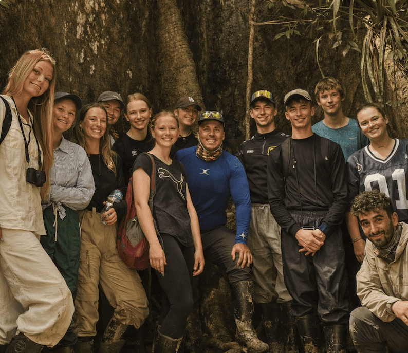 Huéspedes aventureros junto a un árbol gigante en la selva amazónica del Ecuador