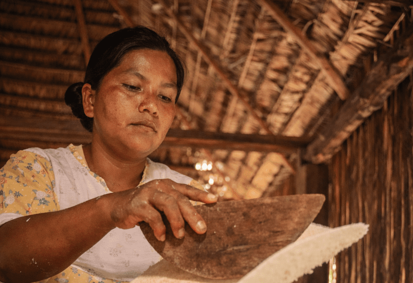 Traditional Amazonian cassava bread being prepared over a wood-fired stove in a jungle community