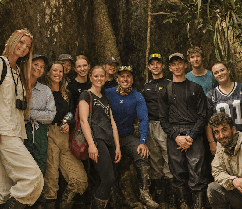 adventurous guests by a giant tree in the amazon rainforest in Ecuador