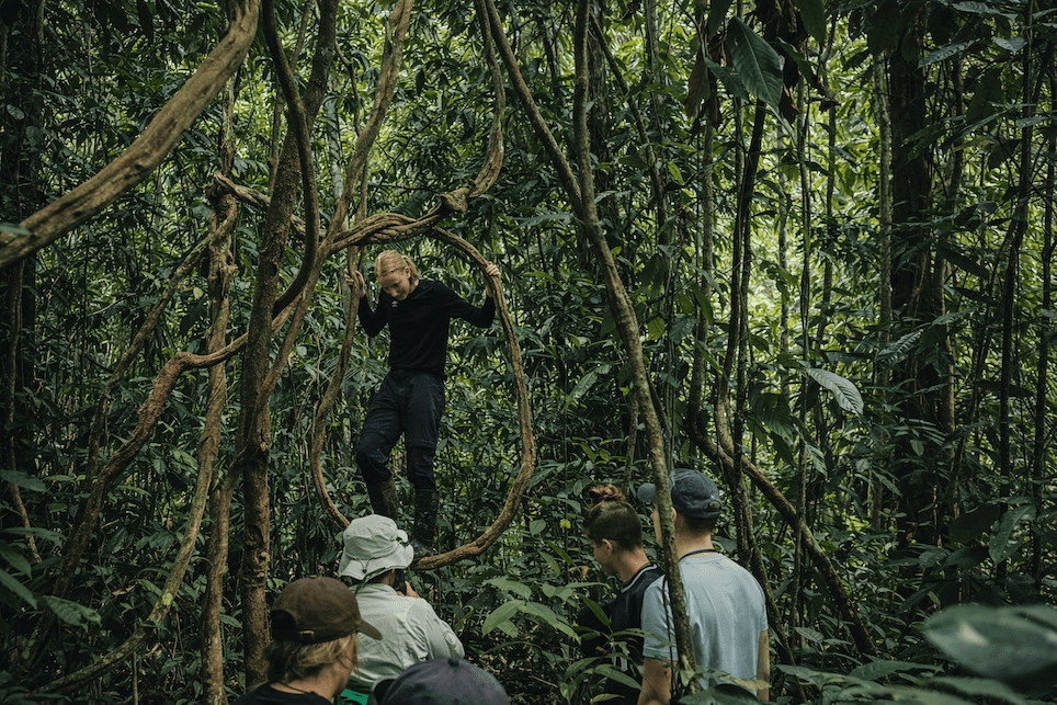 Guest balancing on a jungle vine during a rainforest walk in the Ecuadorian Amazon