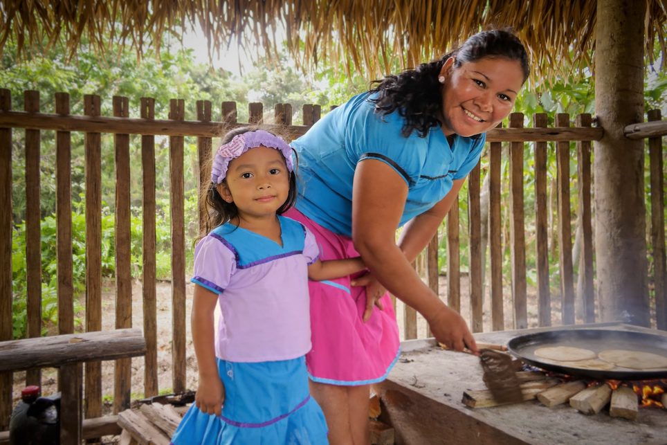 Amazonian community members cooking traditional food in a jungle lodge setting