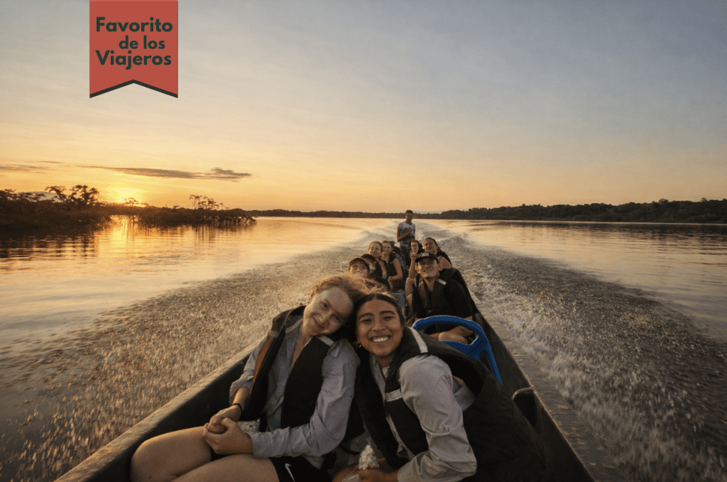 Grupo pequeño de viajeros recorriendo el río Amazonas al atardecer durante una experiencia en la selva